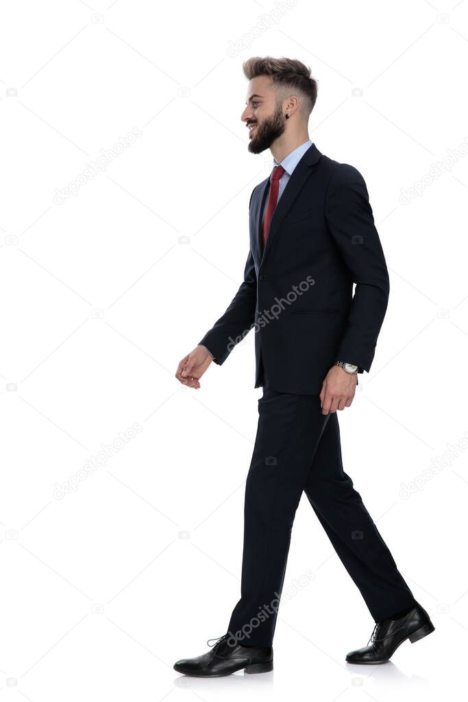 side view of happy businessman smiling and walking isolated on white background