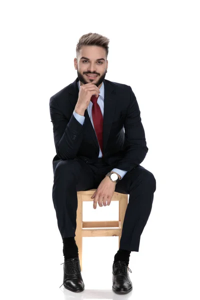 Feliz Joven Empresario Cogido Mano Barbilla Sonriendo Pensando Sentado Aislado —  Fotos de Stock