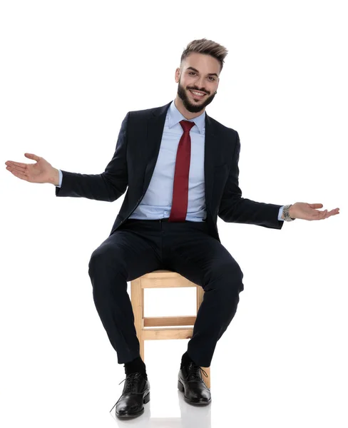 Šťastný Mladý Podnikatel Úsměvem Otevírající Náruč Příjemné Sedí Izolovaný Bílém — Stock fotografie