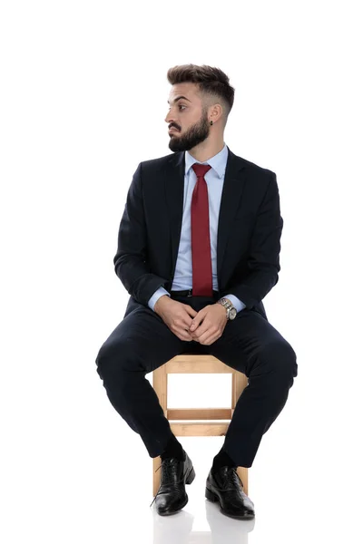 Mladý Podnikatel Obleku Hledá Stranu Sedí Izolované Bílém Pozadí — Stock fotografie