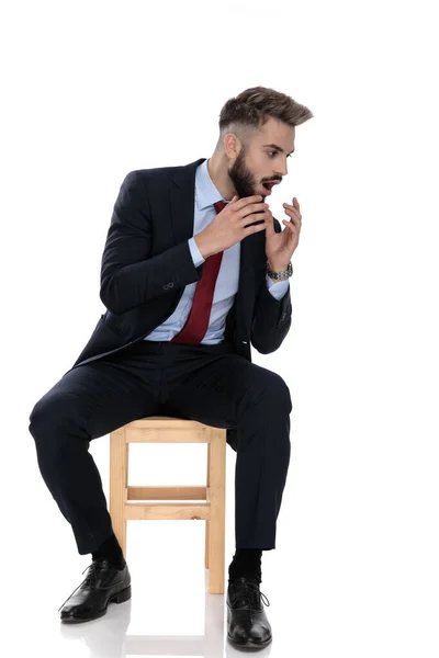 Šokovaný Mladý Podnikatel Obleku Drží Ruce Ústech Dívá Stranu Sedí — Stock fotografie