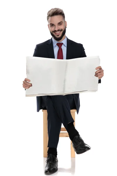 Usmívající Mladý Podnikatel Čtení Novin Sedí Izolované Bílém Pozadí — Stock fotografie