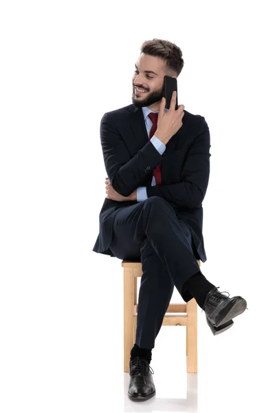Šťastný Mladý Muž Obleku Mluví Telefonu Usmívá Dívá Stranu Sedí — Stock fotografie