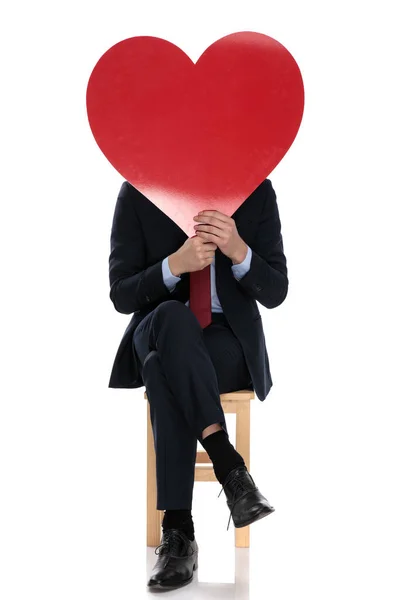 Joven Hombre Negocios Escondido Detrás Gran Corazón Rojo Sentado Aislado — Foto de Stock