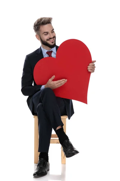 Feliz Joven Empresario Sosteniendo Gran Corazón Rojo Mirando Hacia Lado — Foto de Stock