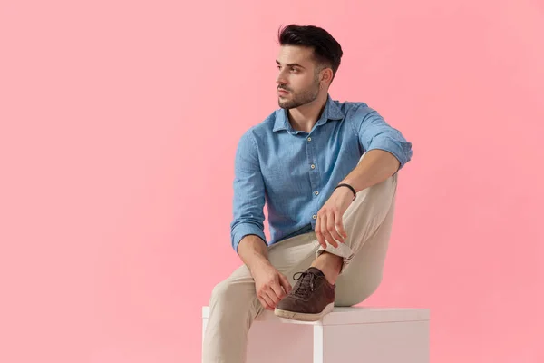 Atraktivní Podnikatel Modré Košili Sedí Nohou Spočívající Kostce Dívá Stranou — Stock fotografie