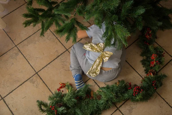 Altın Yay ile Noel ağacı altında çocuk