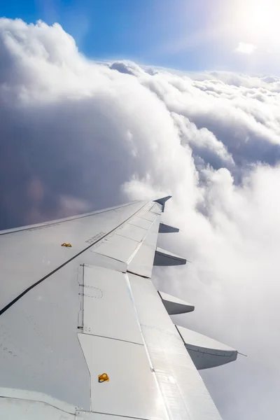 Vleugel van een vliegtuig boven de wolken — Stockfoto