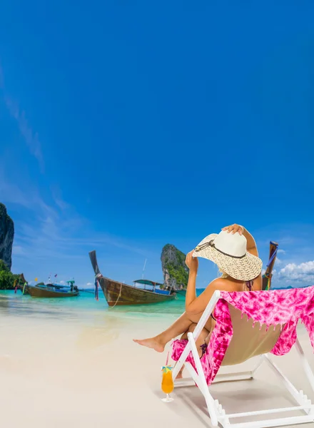 Kvinna på en solstol på stranden — Stockfoto