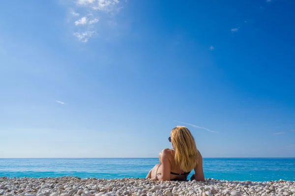 Γυναίκα χαλαρώνοντας στην παραλία στην Ελλάδα — Φωτογραφία Αρχείου