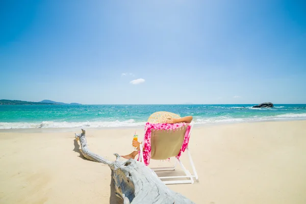 Frau auf einem Liegestuhl am Strand — Stockfoto