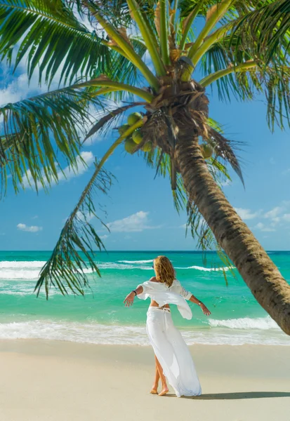 Giovane donna che cammina sulla spiaggia idilliaca — Foto Stock