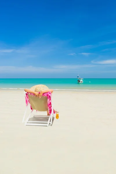 Kvinna på en solstol på stranden — Stockfoto