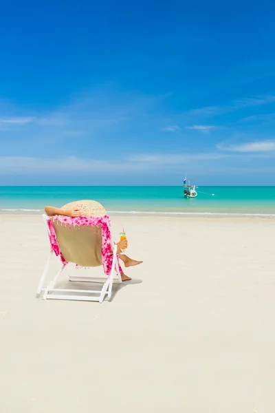 Kvinna på en solstol på stranden — Stockfoto