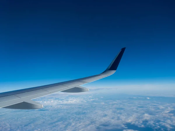 Ala de un avión volando sobre las nubes —  Fotos de Stock