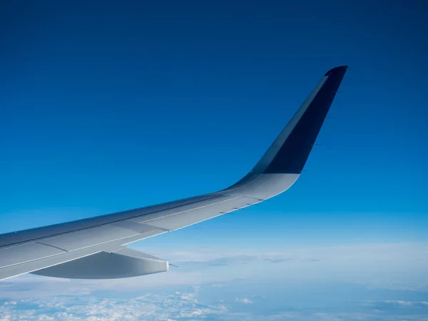 Крыло самолета, летящего над облаками — стоковое фото