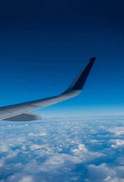 Vleugel van een vliegtuig dat boven de wolken vliegt — Stockfoto