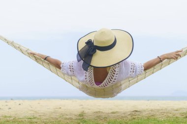 Kumsalda dinlenen bir kadın.