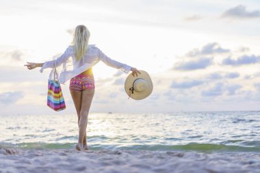 Gün batımında sahilde bir kadın