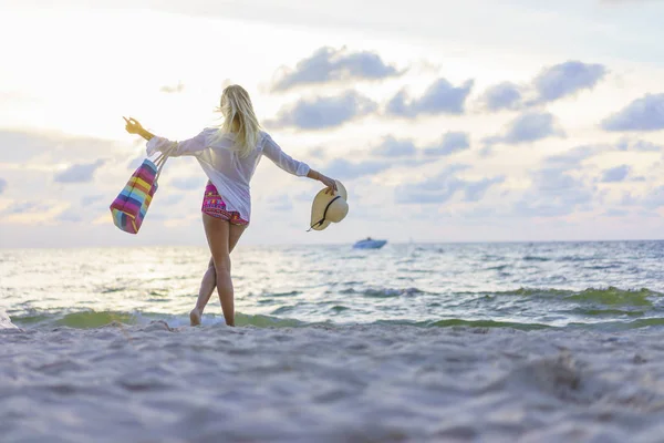 Kvinna på stranden vid solnedgången — Stockfoto