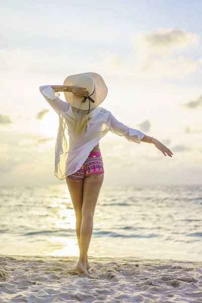 Gün batımında sahilde bir kadın — Stok fotoğraf