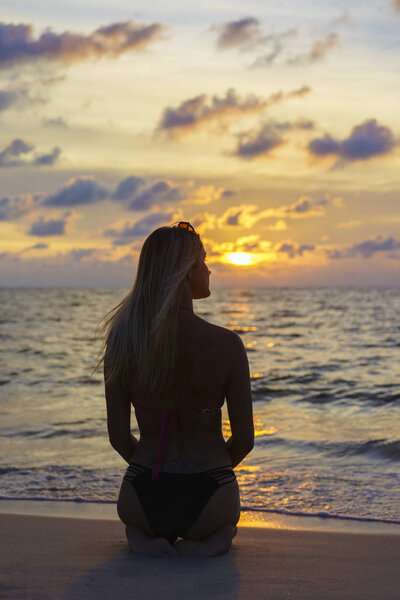 Woman on the beach at sunset