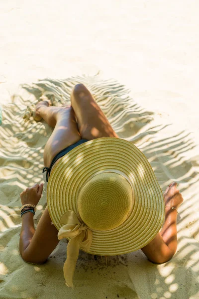 Woman at beach under palm tree with leaf shadow — Stock Photo, Image