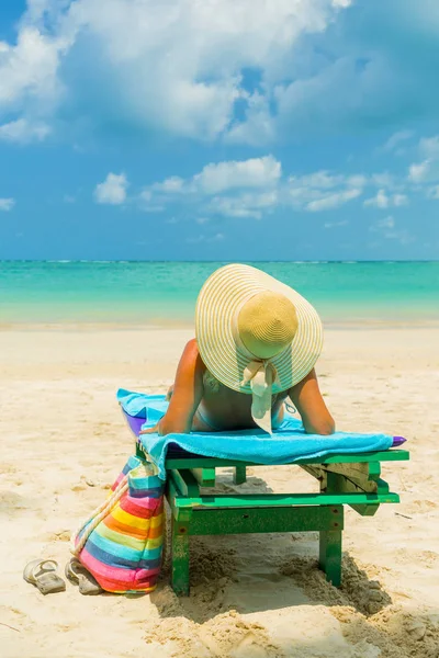 Mujer en una tumbona en la playa — Foto de Stock