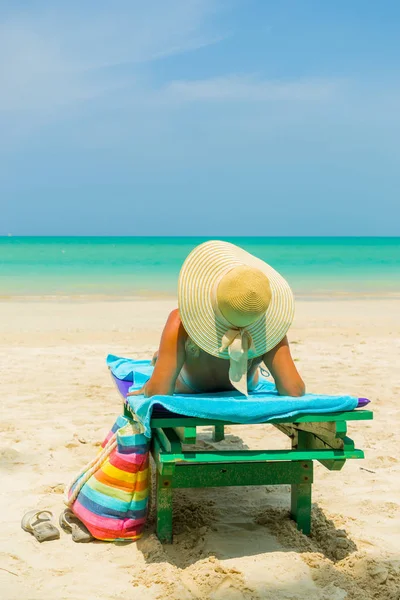 Kobieta siedzi na krześle na plaży — Zdjęcie stockowe