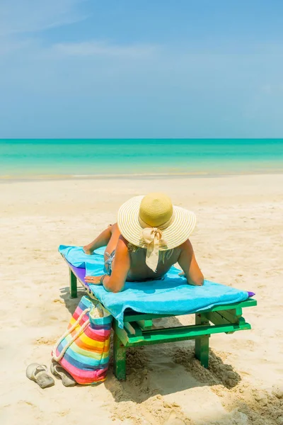 Mulher sentada em uma cadeira na praia — Fotografia de Stock