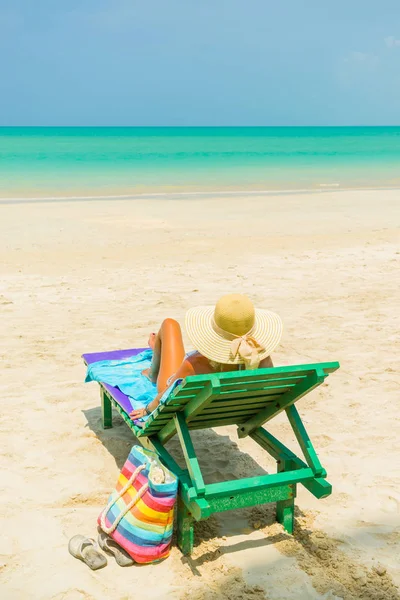 Donna seduta su una sedia in spiaggia — Foto Stock