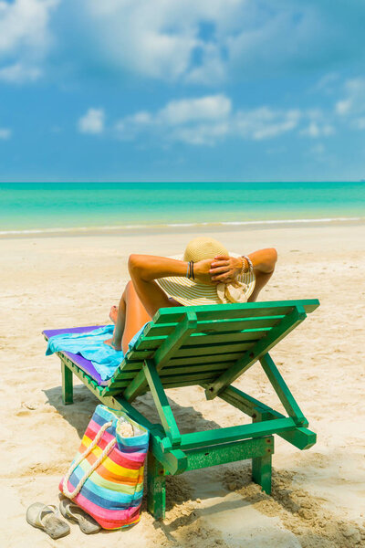 Женщина на шезлонге на пляже
