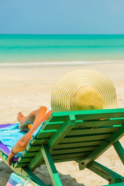 Женщина, сидящая на стуле на пляже — стоковое фото