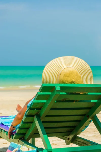 Frau sitzt auf einem Stuhl am Strand — Stockfoto