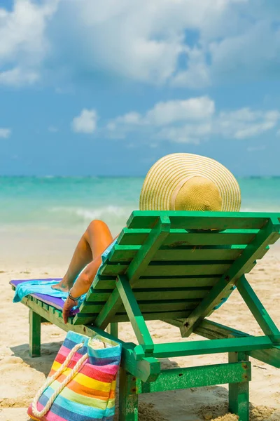 Женщина, сидящая на стуле на пляже — стоковое фото