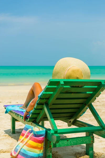 Frau sitzt auf einem Stuhl am Strand — Stockfoto