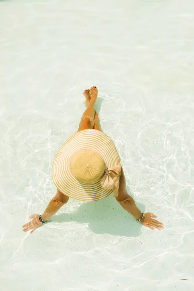 Νεαρή γυναίκα που κάθεται στο περβάζι της πισίνας. — Φωτογραφία Αρχείου
