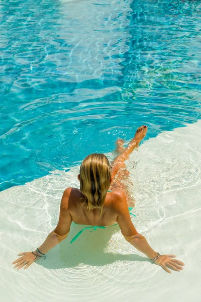 Giovane donna seduta sul bordo della piscina. — Foto Stock