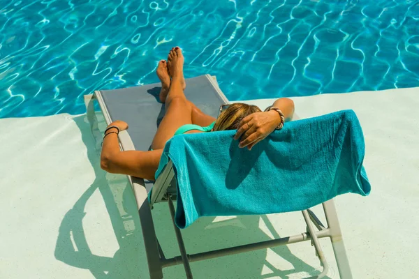 Mujer disfrutando en la cama de sol en la piscina — Foto de Stock