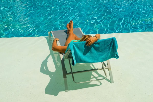 Женщина наслаждается на шезлонге у бассейна — стоковое фото