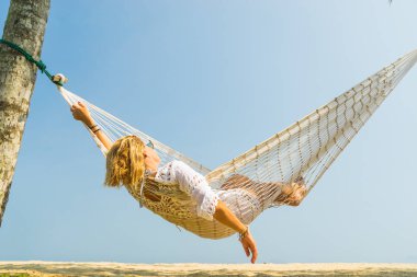 Kumsalda dinlenen bir kadın.