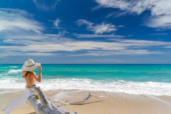 Νεαρή γυναίκα στέκεται σε μια παραλία και να απολαύσετε τον ήλιο — Φωτογραφία Αρχείου
