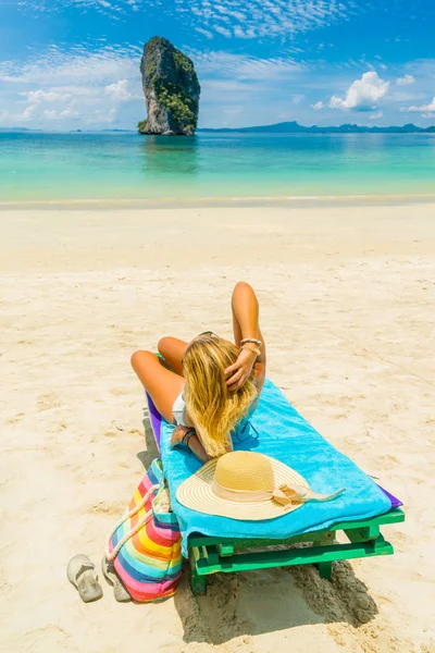 Kvinna sitter på en säng på stranden — Stockfoto