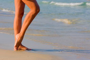  kum deniz kenarında birlikte kadının bacakları gitmek. 