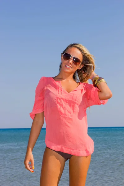 Mulher de camisa rosa na praia — Fotografia de Stock