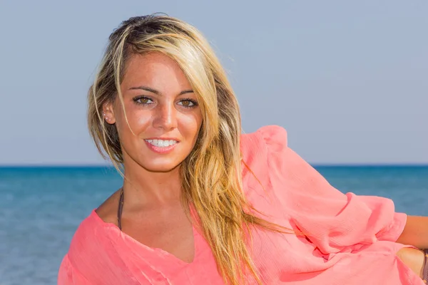 Vrouw in roze shirt op het strand — Stockfoto