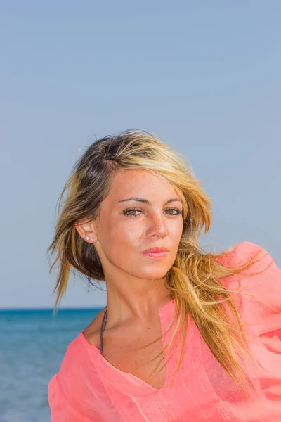 Mulher de camisa rosa na praia — Fotografia de Stock