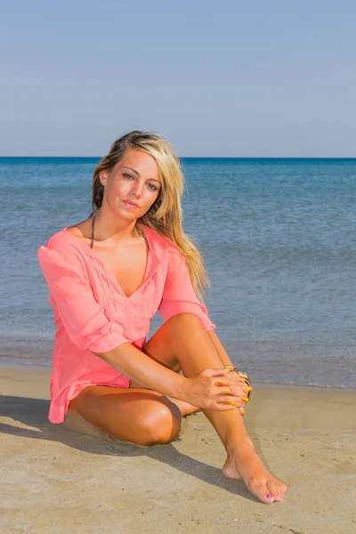 Mulher de camisa rosa na praia — Fotografia de Stock