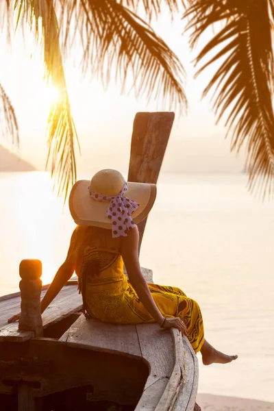 Woman on a long tail boat at sunset — Stock Photo, Image