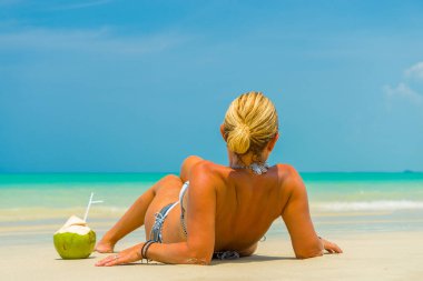 Güzel bir tropik sahilde kum üzerinde döşeme kadın 